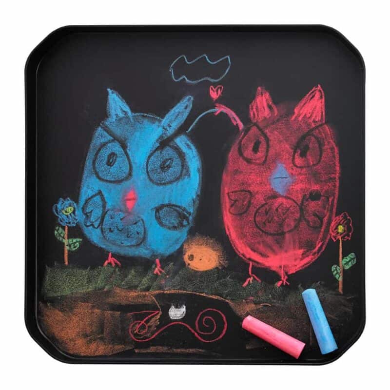 A black tray with chalk drawings on it