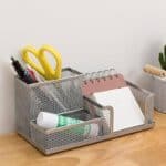 a metal organizer with stationery items in it