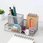 a desk with a notebook and a pen holder