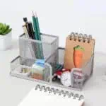 a desk with a notebook and a pen holder