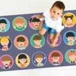 a child sitting on a rug with cartoon faces