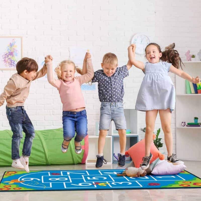 A group of kids jumping on a rug