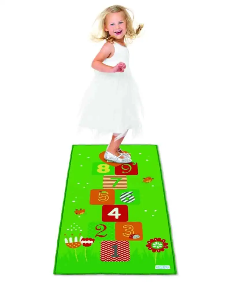 a girl standing on a hopscotch mat