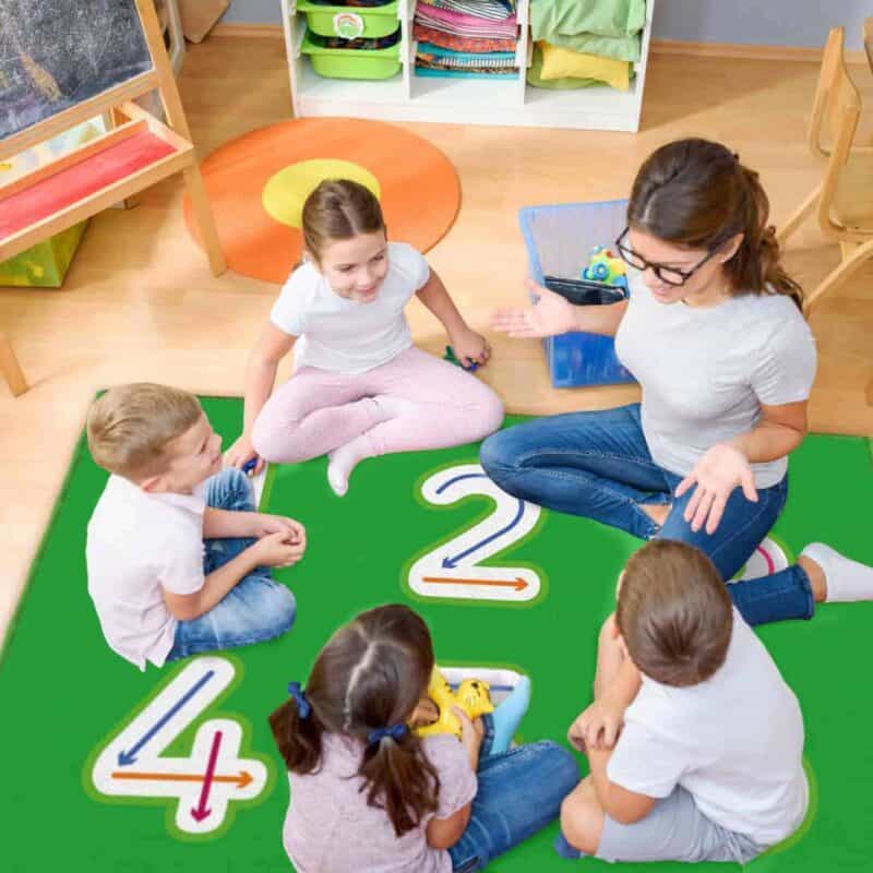 A group of children sitting on a rug in a classroom