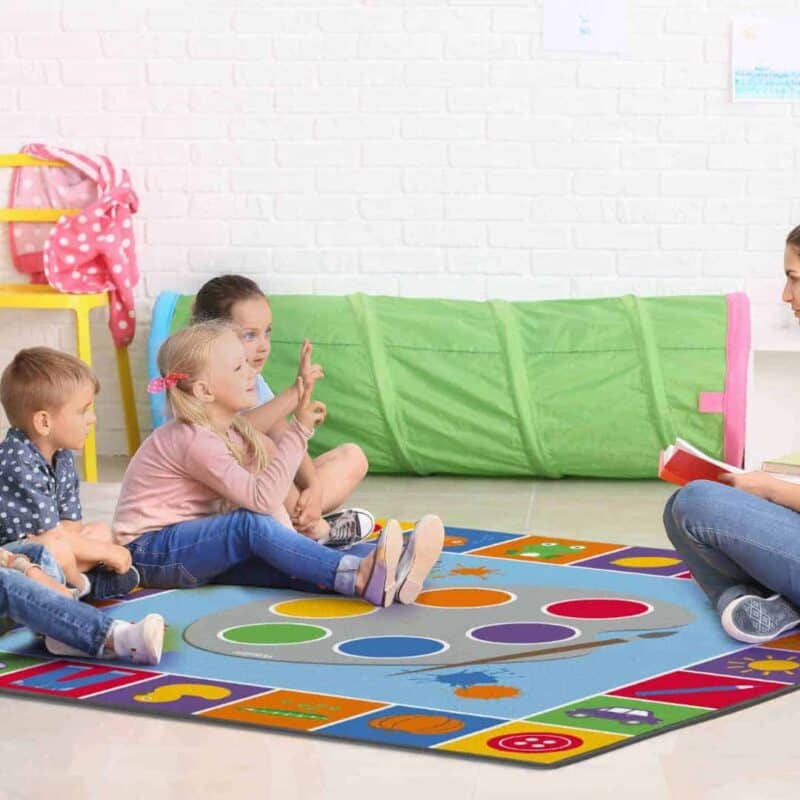 A woman sitting on a rug with children