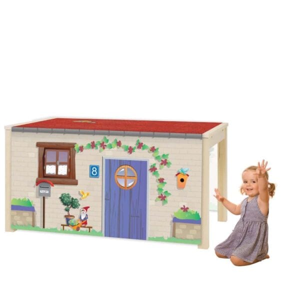 a child sitting next to a toy house