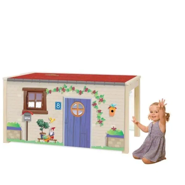 a child sitting next to a toy house