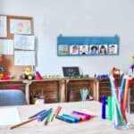a room with a table and desk with colorful markers