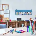 a room with a table and desk with colorful markers
