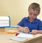 Child working with educational tools on desk.