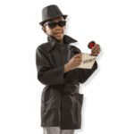 Child dressed as a secret agent with trench coat, sunglasses, and secret file, role-playing as a spy.