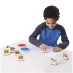 Child playing with wooden toy stamps.