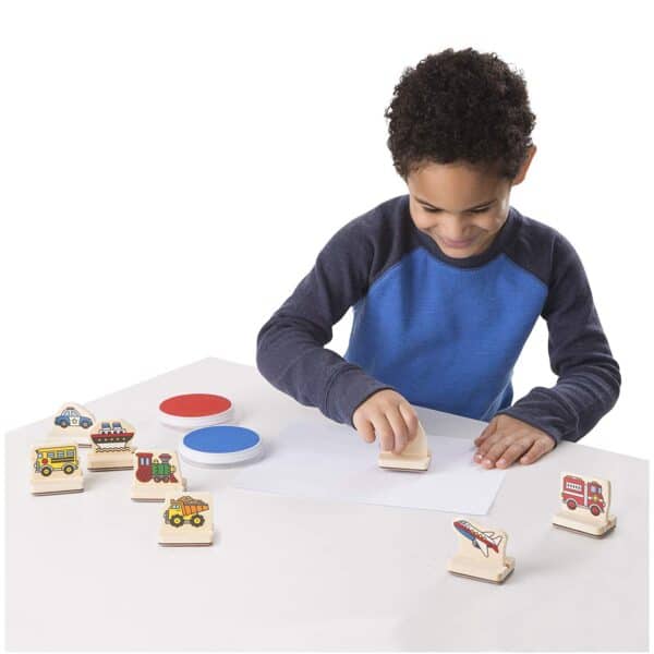 Child playing with wooden toy stamps.