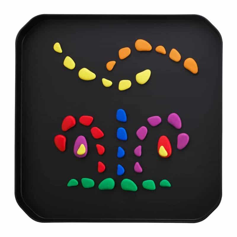 A black tray with colorful stones on it