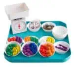 a tray with different colored bowls of food and a scale