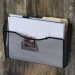 a black wire file holder with papers inside
