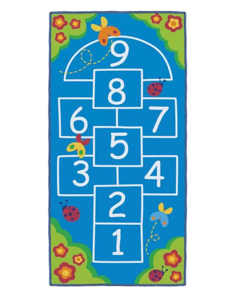 A blue rug with white numbers and butterflies