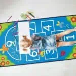 a girl lying on a rug with markers