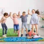 a group of kids jumping on a rug