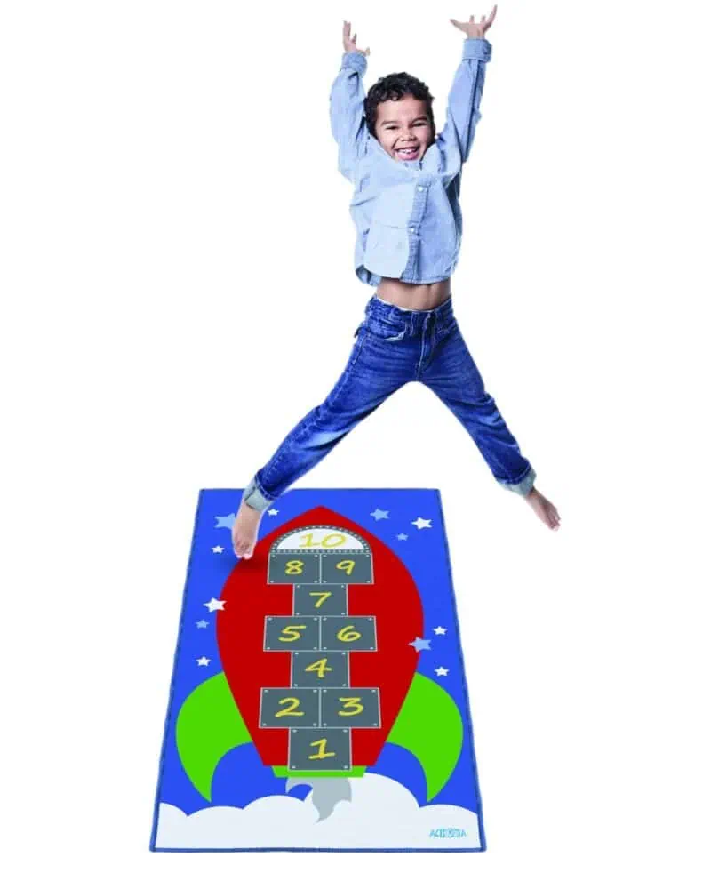 A boy jumping on a rug