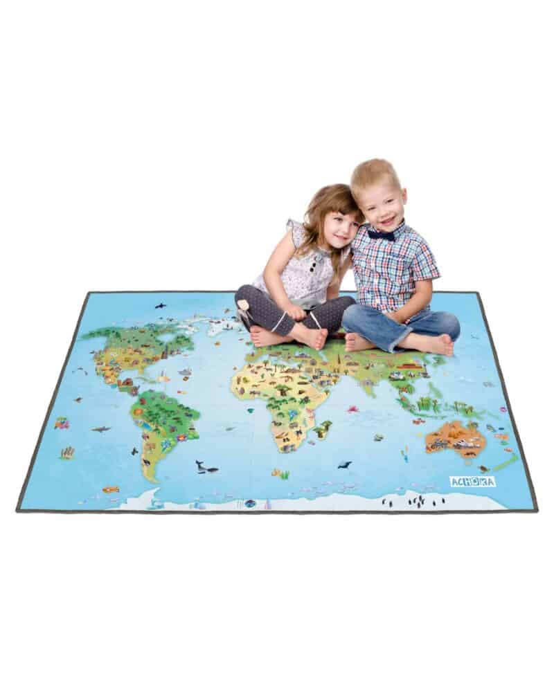 A boy and girl sitting on a map