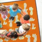 a group of children standing on a rug