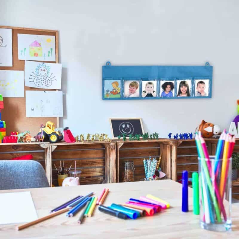A room with a table and desk with colorful markers
